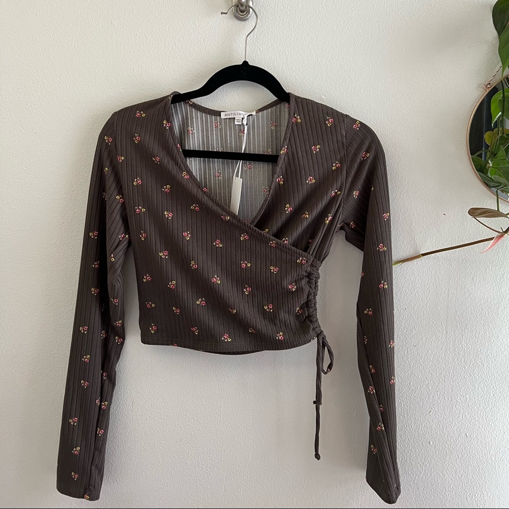 Long sleeve crop top with cute flower detail.
